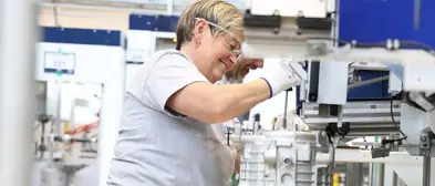 Worker handling a machine wearing goggles and gloves.jpg
