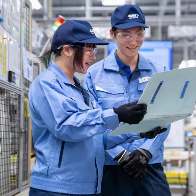 Two GKN Automotive workers looking at clipboard and smiling.jpg
